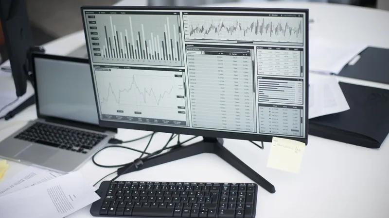 A workspace with computers displaying analytical graphs, representing autonomous AI-driven paid ad optimization.