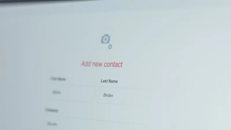 A computer screen shows a new contact entry form, representing CRM-based lead nurturing automation like HubSpot's Breeze AI.