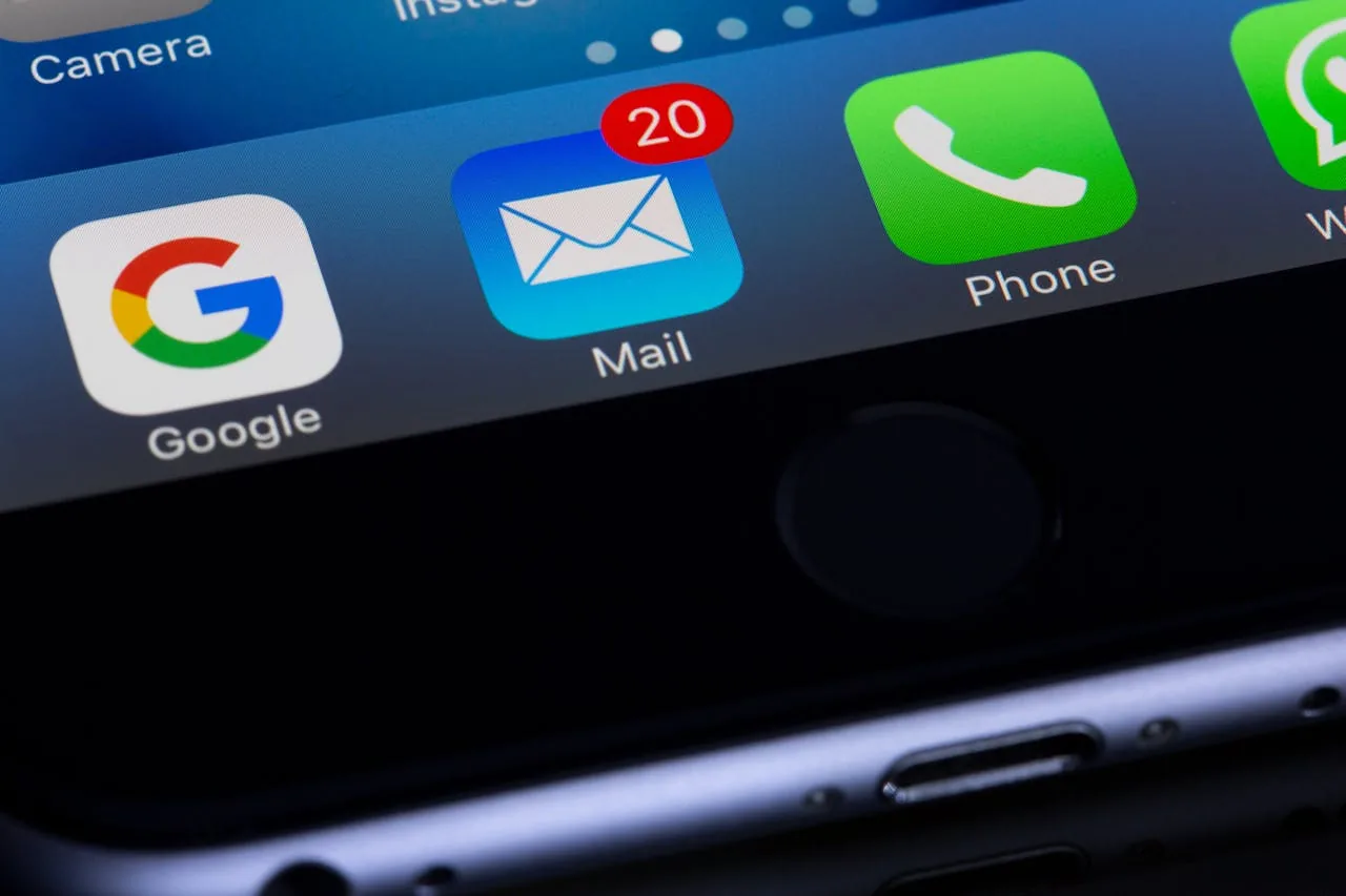 Close-up of a smartphone home screen showing the Google, Mail, Phone and WhatsApp icons, with a red badge on Mail counting 20 unread messages.